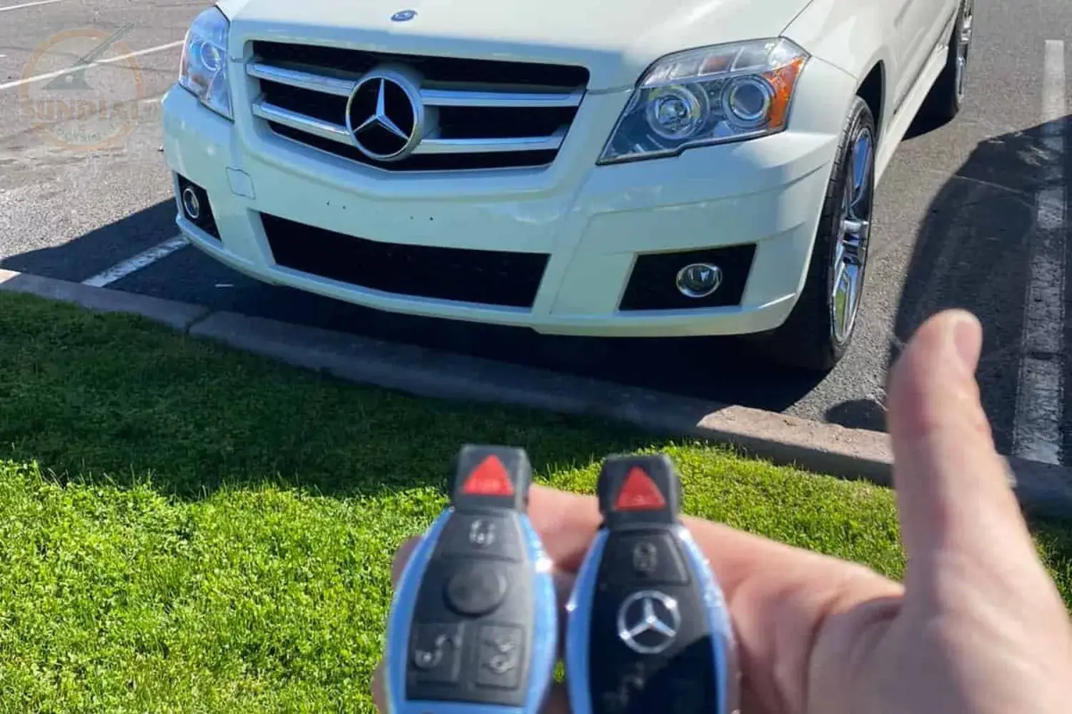 Holding car keys in front of a white Mercedes-Benz.