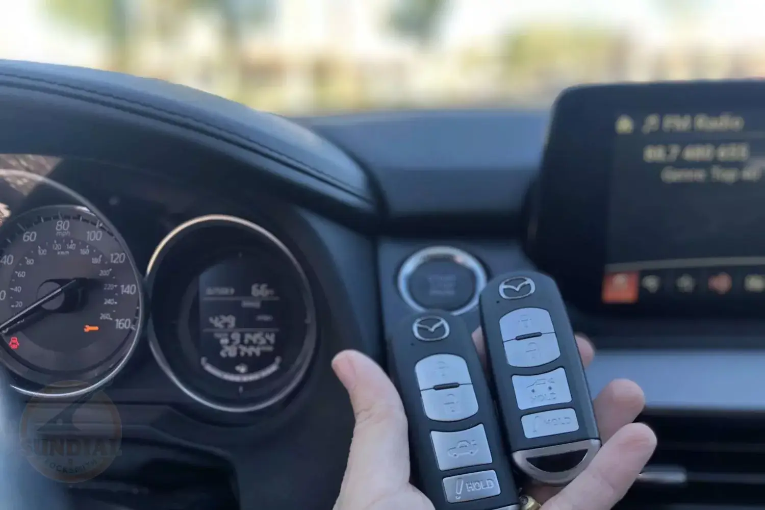 Car dashboard and held remote key fobs.