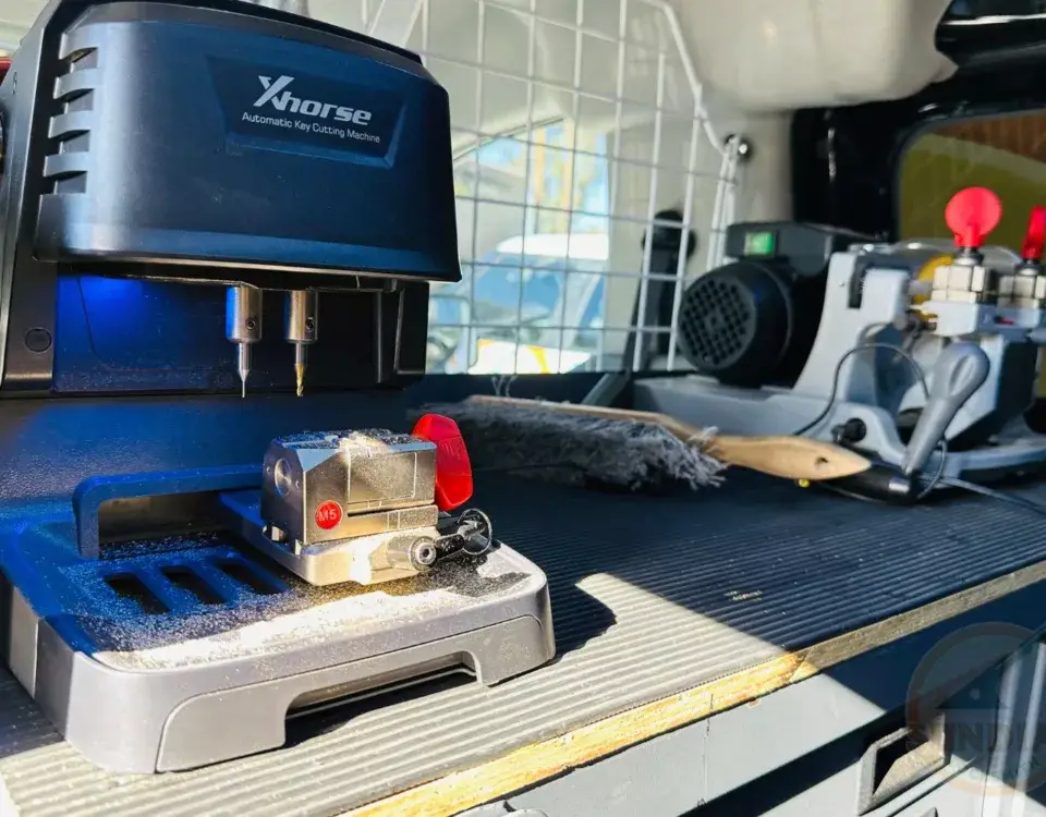 Automatic key cutting machine in workshop setting.