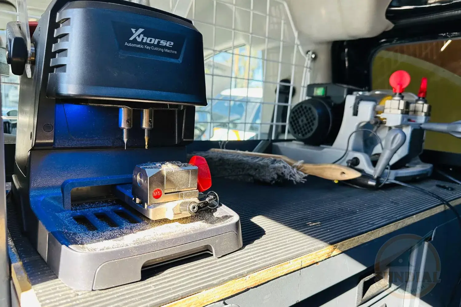 Automatic key cutting machine in workshop setting.