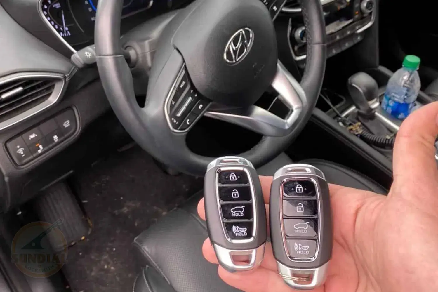 Hand holding car key fobs with vehicle dashboard background.