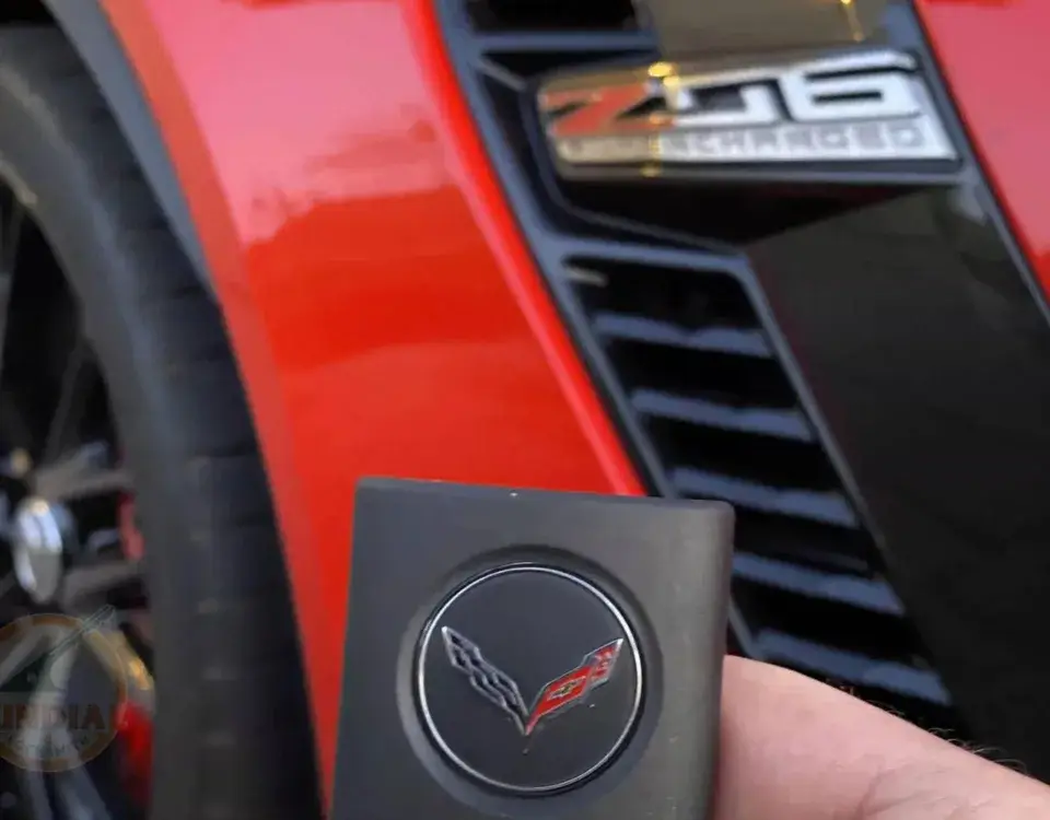 Red Corvette Z06 with key fob in foreground.