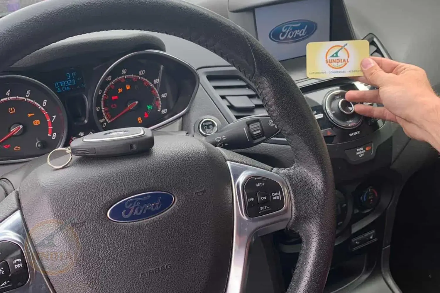 Person holding card in car interior.