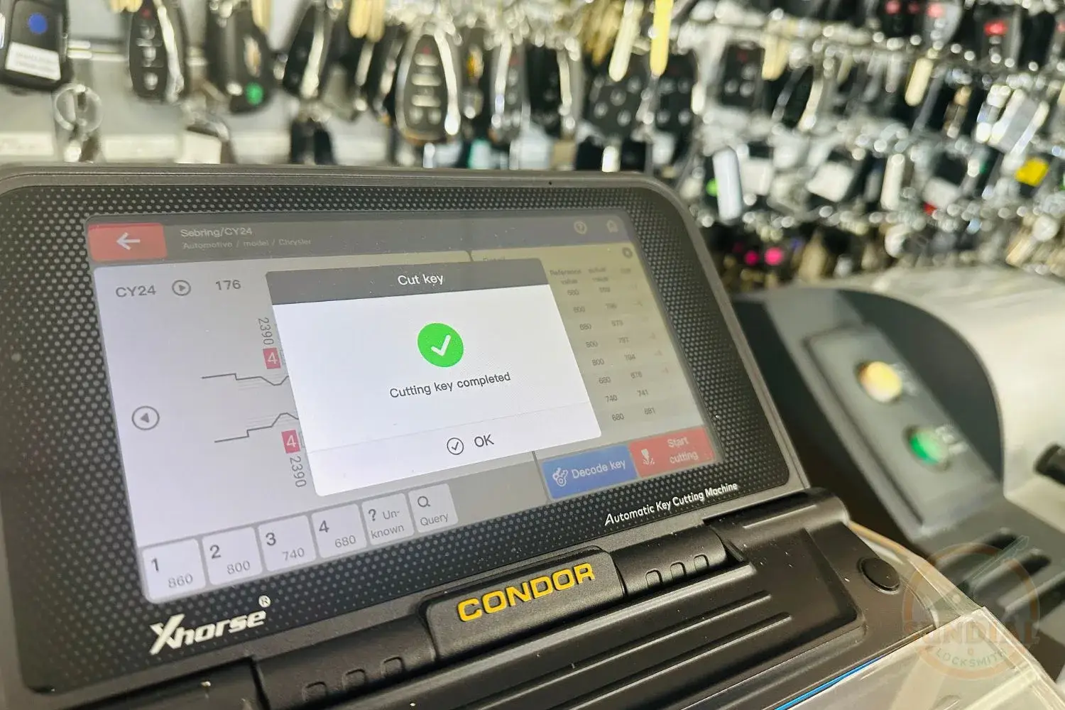 Key cutting machine with completed task on screen.