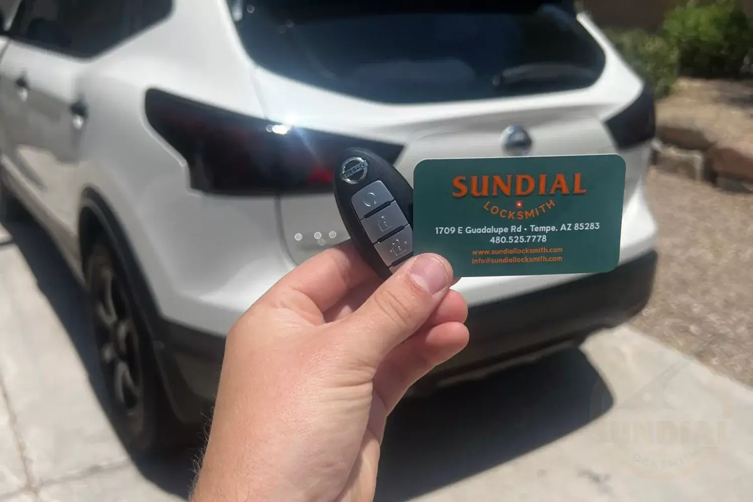 Locksmith expertly programming a car key for a Nissan vehicle.