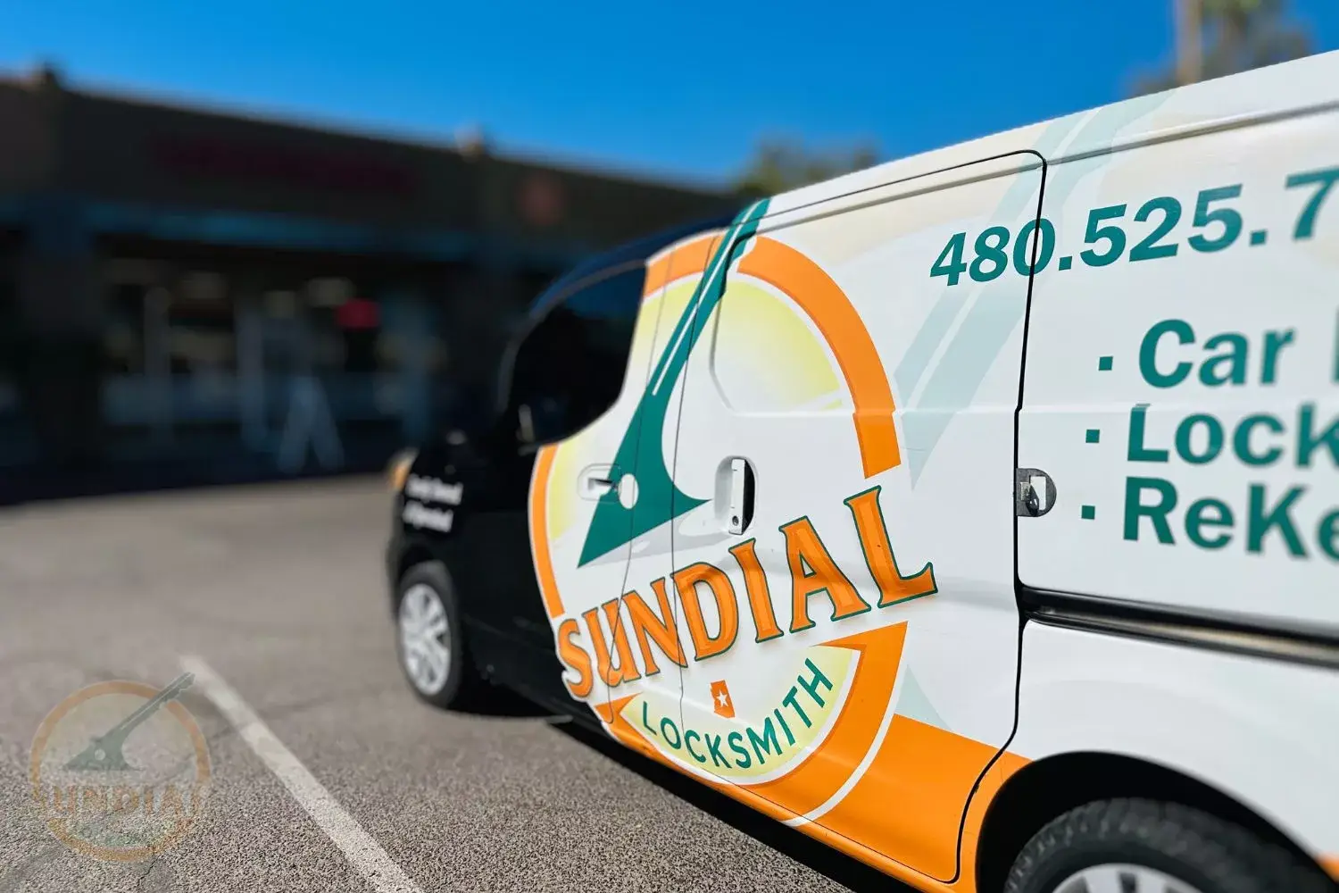 Branded locksmith van parked outside a business.